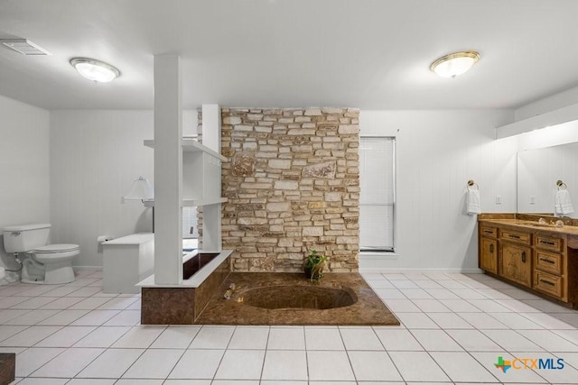 bathroom featuring vanity, toilet, tile patterned floors, and a tub