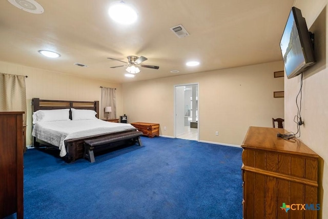 bedroom featuring ceiling fan, dark colored carpet, and ensuite bath