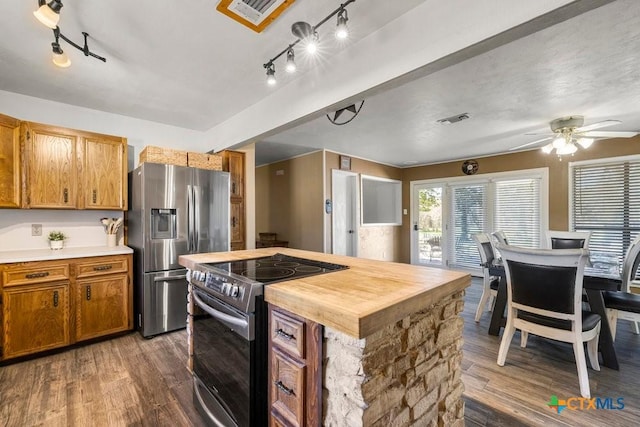 kitchen featuring ceiling fan, appliances with stainless steel finishes, dark hardwood / wood-style flooring, and a center island