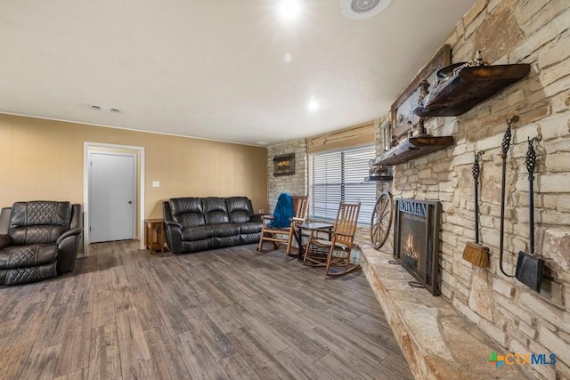 living room featuring a stone fireplace and hardwood / wood-style floors