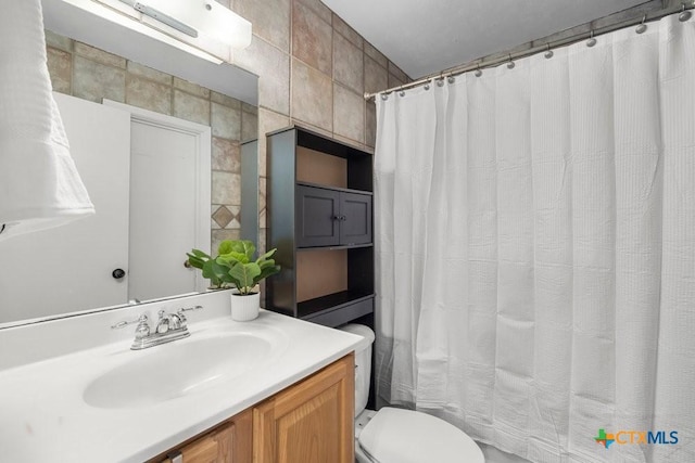 bathroom featuring toilet, vanity, tile walls, and curtained shower