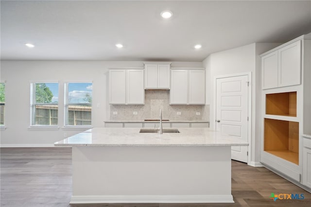 kitchen featuring white cabinets, sink, an island with sink, and hardwood / wood-style floors
