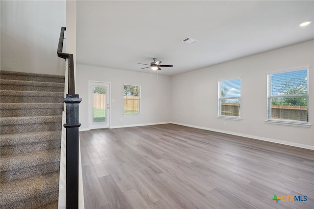unfurnished living room featuring ceiling fan and hardwood / wood-style flooring