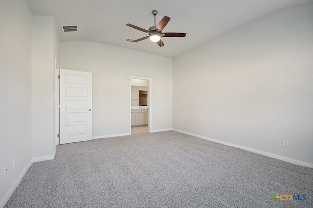 unfurnished bedroom with carpet, ceiling fan, ensuite bathroom, and vaulted ceiling