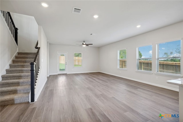 unfurnished living room with light hardwood / wood-style floors, ceiling fan, and a healthy amount of sunlight