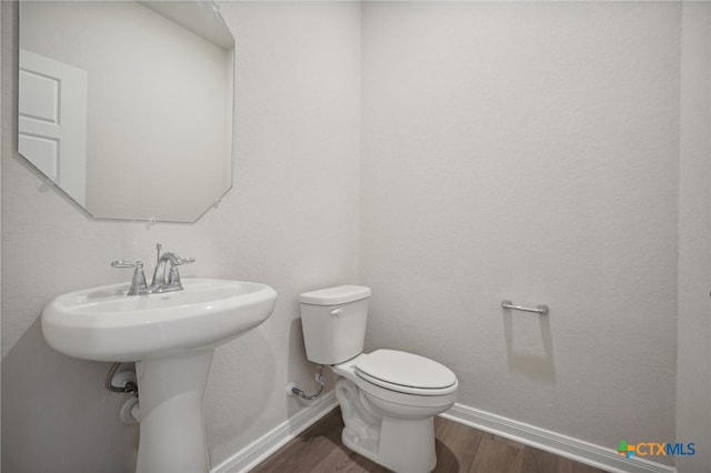 bathroom featuring wood-type flooring and toilet