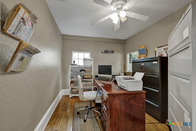 608 S Guadalupe St, San Marcos, TX 78666 - home office featuring a textured wall, wood finished floors, a ceiling fan, and a textured ceiling
