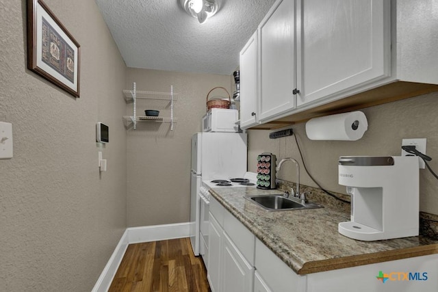 608 S Guadalupe St, San Marcos, TX 78666 - kitchen featuring white microwave, dark wood-style flooring, white cabinetry, a textured ceiling, and a textured wall