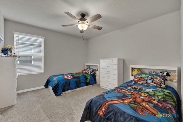 carpeted bedroom featuring baseboards and a ceiling fan