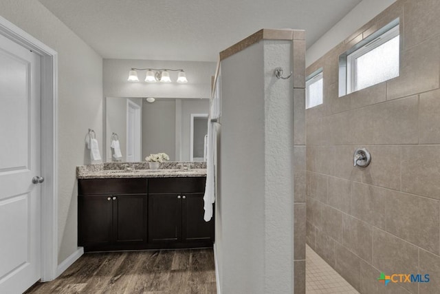 full bathroom with walk in shower, wood finished floors, and vanity