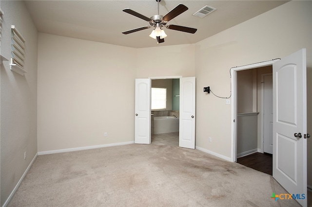 unfurnished bedroom featuring ceiling fan, connected bathroom, and carpet