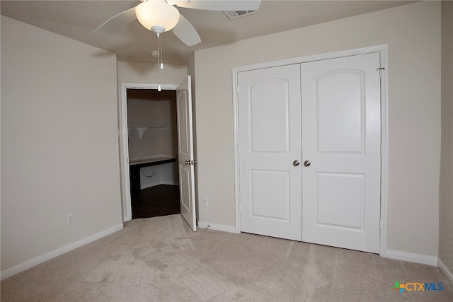 unfurnished bedroom featuring light carpet, ceiling fan, and a closet