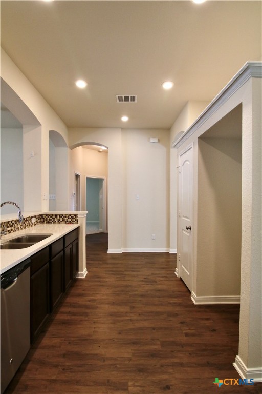 kitchen featuring dishwasher, dark brown cabinets, dark hardwood / wood-style floors, and sink