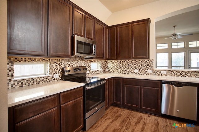 kitchen featuring light wood-type flooring, stainless steel appliances, a wealth of natural light, and backsplash