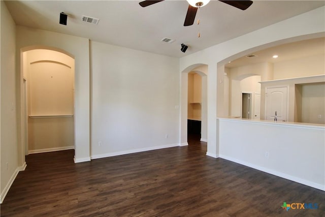 7841 Old Gate Rd, Temple, TX 76502 - empty room with a ceiling fan, dark wood-style floors, arched walkways, and baseboards