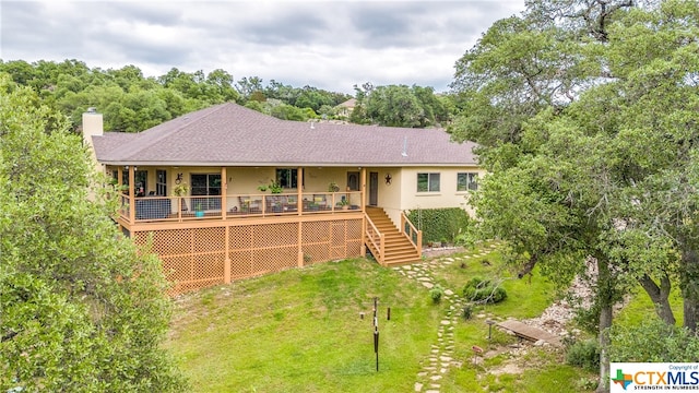 rear view of house featuring a yard and a deck