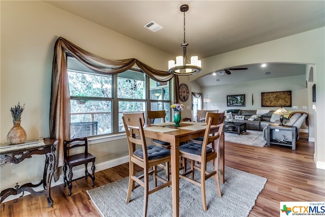 dining space featuring wood-type flooring and an inviting chandelier