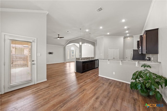 5208 Siltstone Loop, Killeen, TX 76542 - kitchen with crown molding, a peninsula, freestanding refrigerator, dark brown cabinets, and arched walkways
