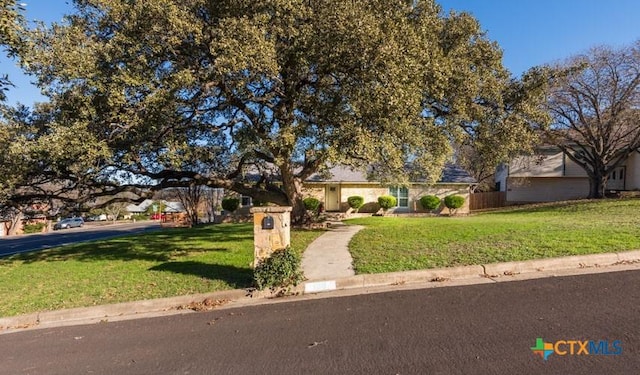 view of front of home featuring fence and a front yard