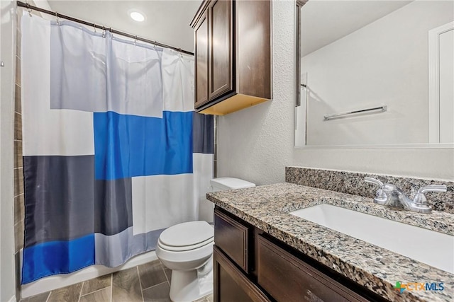 606 Hobby Rd, Copperas Cove, TX 76522 - bathroom featuring toilet, vanity, a shower with shower curtain, and a textured wall