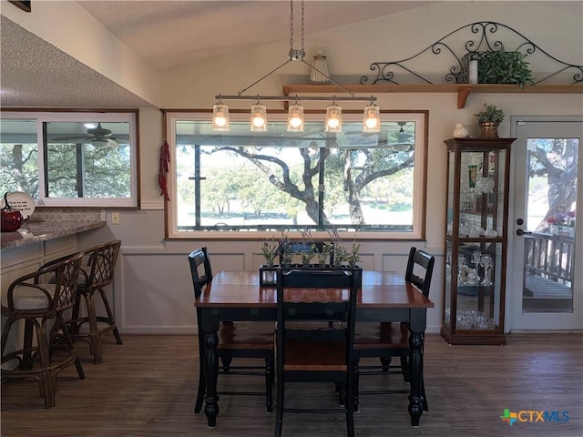 dining area with lofted ceiling, dark wood-style flooring, and a healthy amount of sunlight