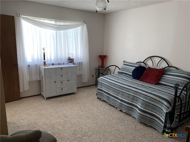 bedroom featuring light carpet and a textured ceiling