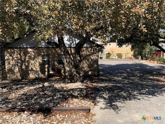 exterior space with stone siding and fence