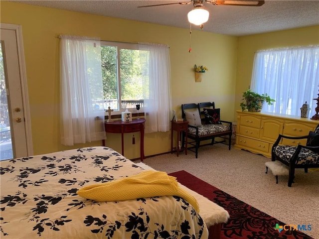 bedroom featuring a textured ceiling, ceiling fan, and carpet