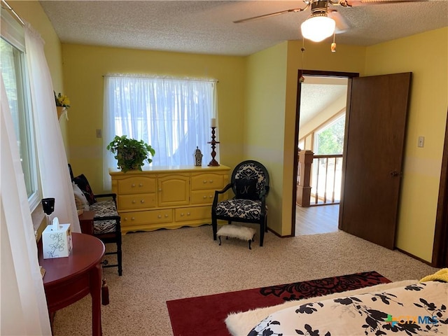 bedroom with a textured ceiling, ceiling fan, and light colored carpet