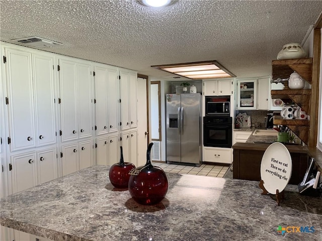 kitchen with visible vents, white cabinets, a textured ceiling, black appliances, and a sink