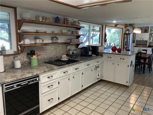 kitchen featuring open shelves, backsplash, light tile patterned flooring, white cabinets, and black appliances