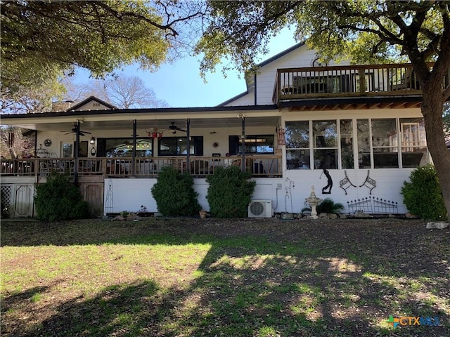 rear view of house featuring ac unit, a lawn, and a ceiling fan