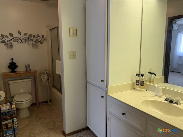 full bath featuring combined bath / shower with glass door, vanity, toilet, and tile patterned floors