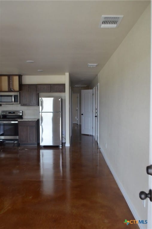 kitchen featuring dark hardwood / wood-style flooring, dark brown cabinets, and appliances with stainless steel finishes