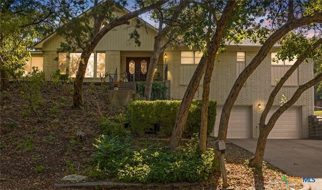 view of front of house with concrete driveway, an attached garage, and brick siding