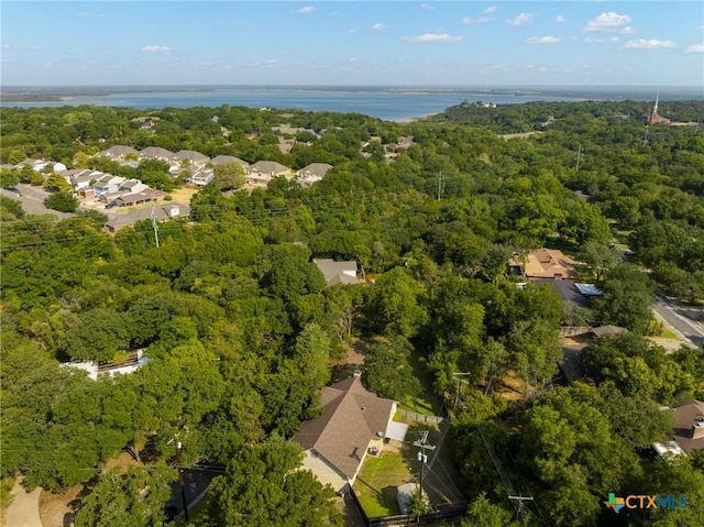 birds eye view of property featuring a forest view and a water view