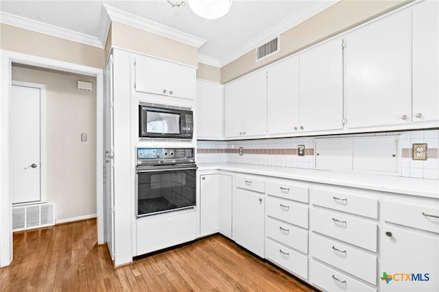 kitchen with black appliances, light countertops, and visible vents