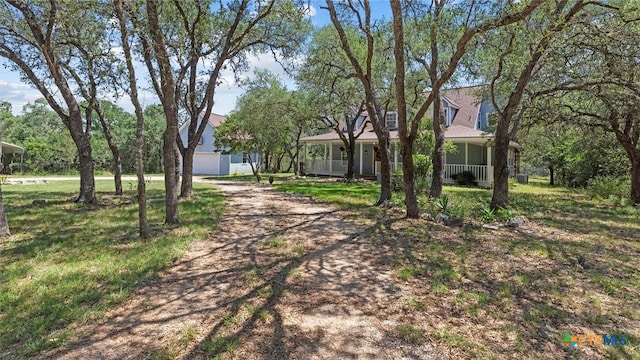 689 Abels Way, Canyon Lake, TX 78133 - view of front of home with covered porch, dirt driveway, and a garage