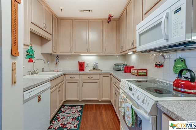 kitchen with dark wood-type flooring, light brown cabinets, white appliances, and sink