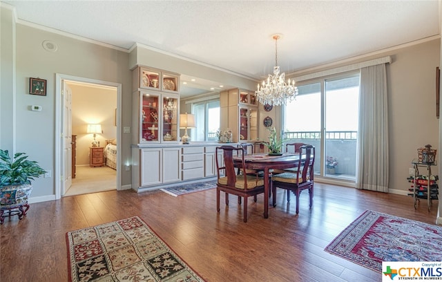 dining space with ornamental molding, plenty of natural light, and hardwood / wood-style flooring