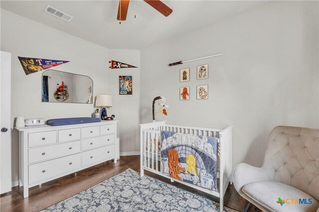 6402 Castle Gap Dr, Killeen, TX 76549 - bedroom featuring dark wood-type flooring, a crib, baseboards, and ceiling fan