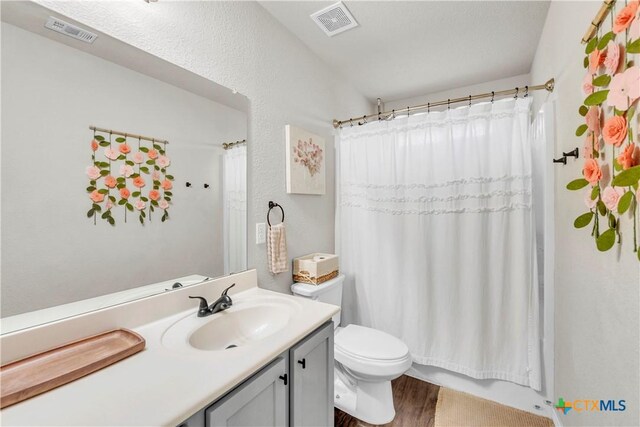 6402 Castle Gap Dr, Killeen, TX 76549 - bathroom featuring vanity, toilet, wood finished floors, and shower / bath combo