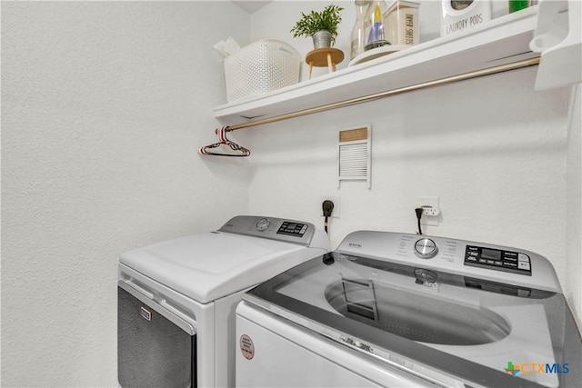 6402 Castle Gap Dr, Killeen, TX 76549 - laundry room featuring washing machine and clothes dryer and a textured wall