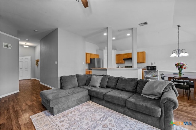 7317 Galleta Ct, Temple, TX 76502 - living room featuring dark wood-type flooring, a chandelier, vaulted ceiling, a ceiling fan, and baseboards
