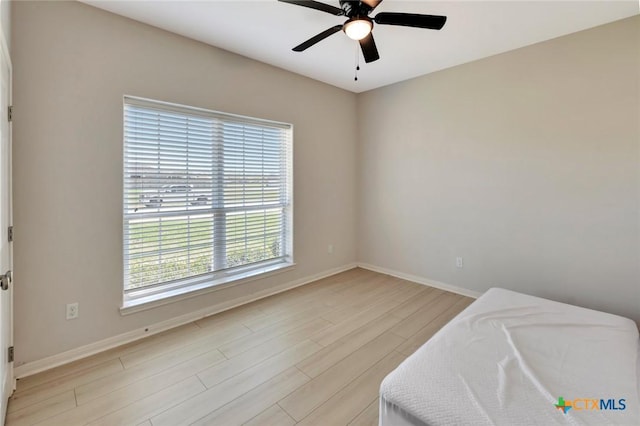 bedroom featuring a ceiling fan, light wood-type flooring, and baseboards