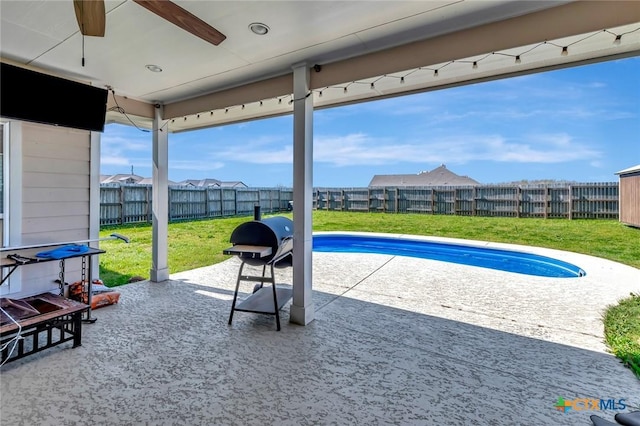 view of swimming pool featuring a patio, a ceiling fan, a fenced backyard, grilling area, and a lawn