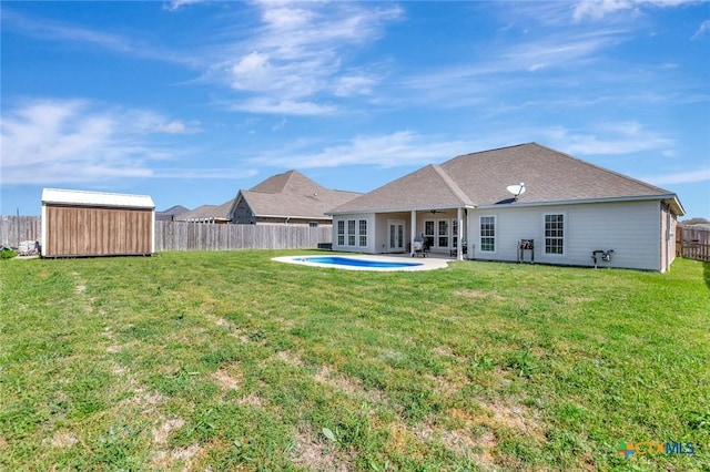 rear view of property with a storage unit, a fenced backyard, french doors, a yard, and a patio area