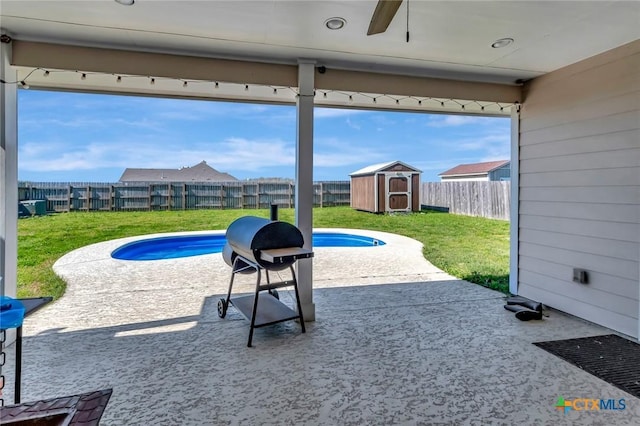 view of patio / terrace with a storage shed, an outdoor structure, a fenced backyard, area for grilling, and a ceiling fan