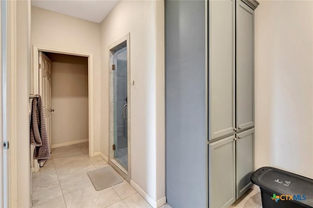 full bath with tile patterned flooring, baseboards, and a stall shower