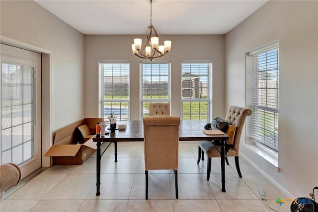 dining room featuring a notable chandelier, baseboards, and light tile patterned floors